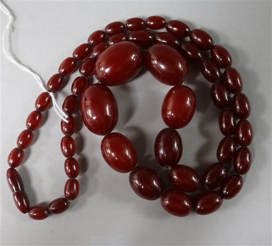 A single strand graduated simulated cherry amber oval bead necklace, gross weight 68 grams, 70cm.